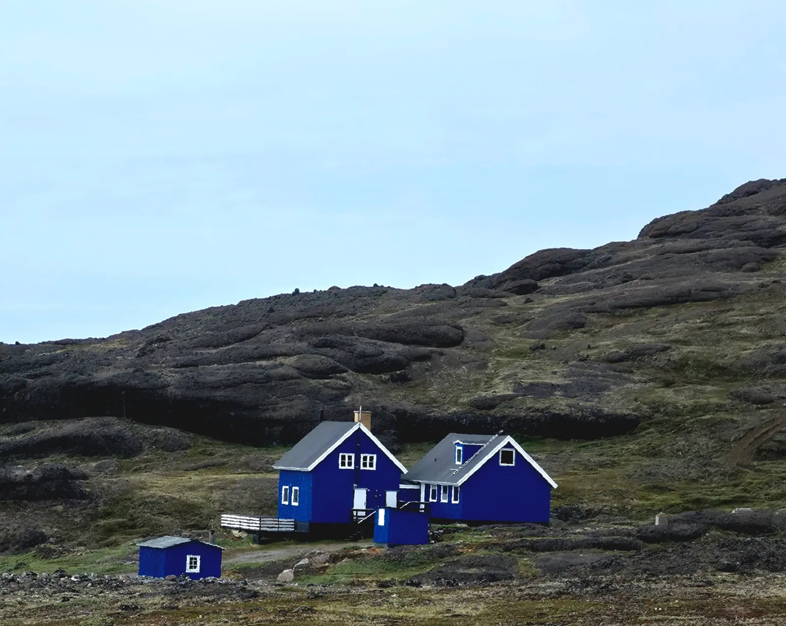 Blue Arctic houses beneath a broad open sky.