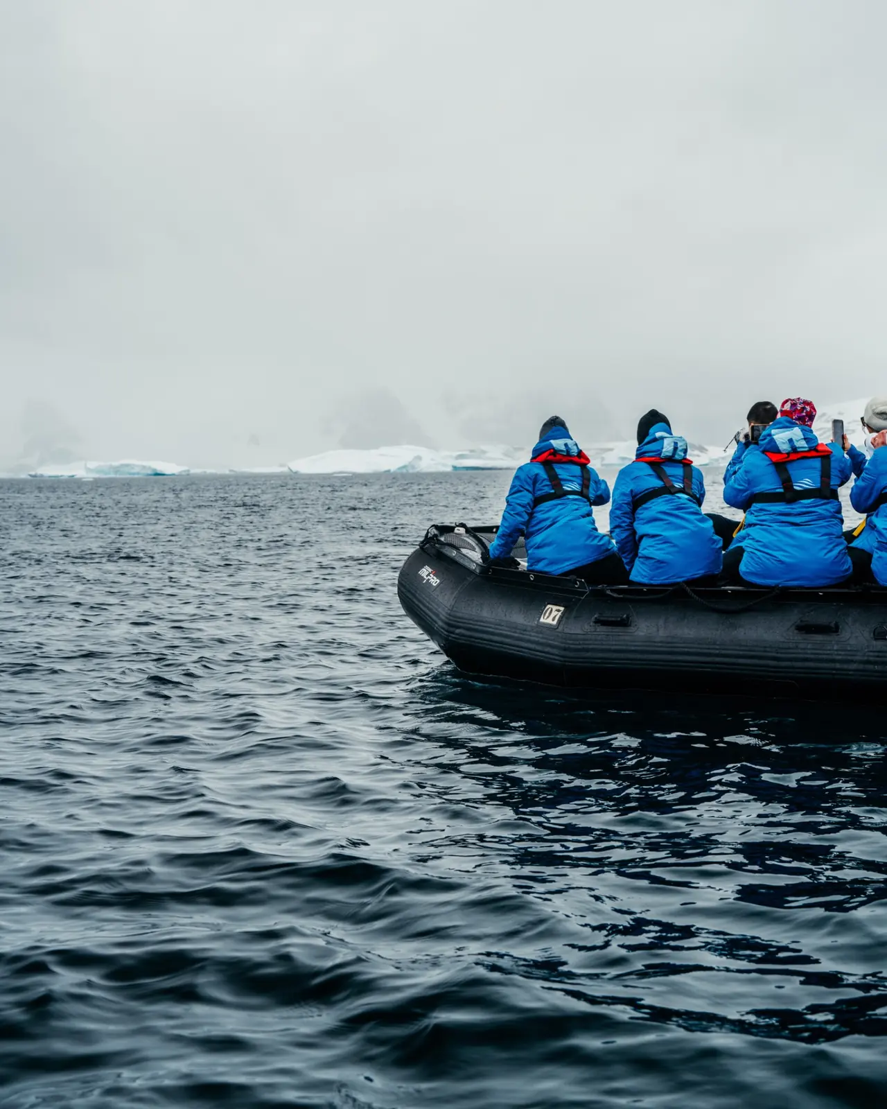 Travellers exploring Antarctic waters by zodiac.
