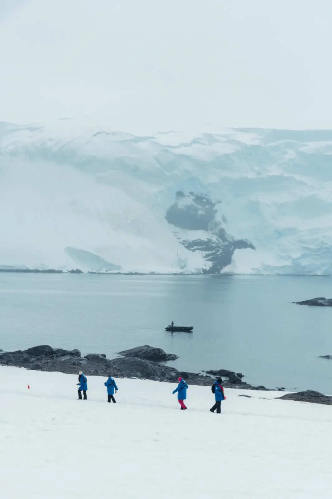 Expedition travellers crossing a snowy polar shoreline.