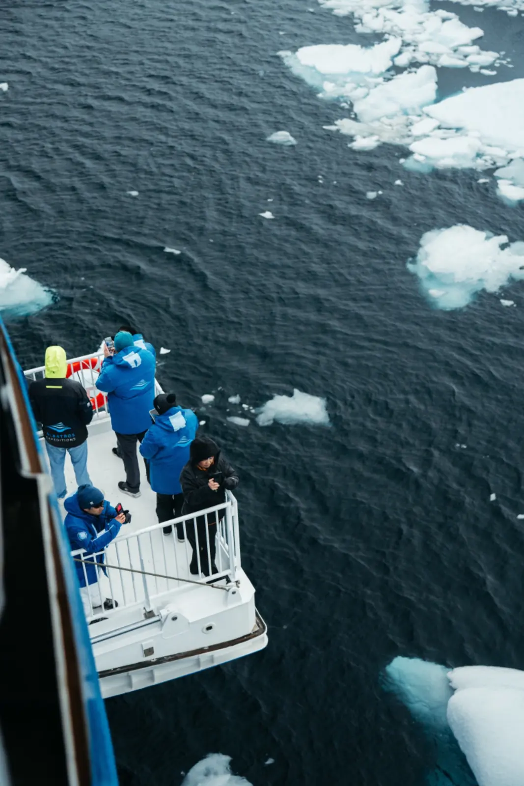 Expedition guests viewing drifting ice from a ship deck.