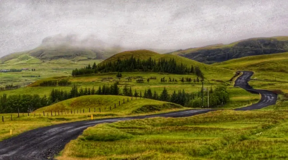 Winding road through green Icelandic highlands.