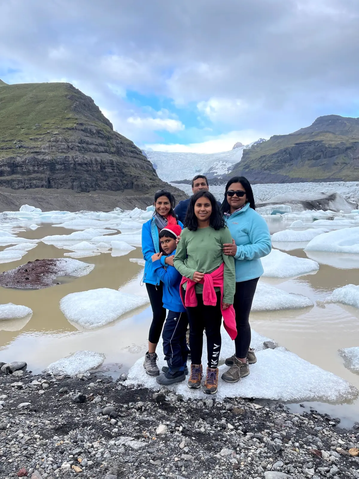 Travellers together beside a glacier lagoon.