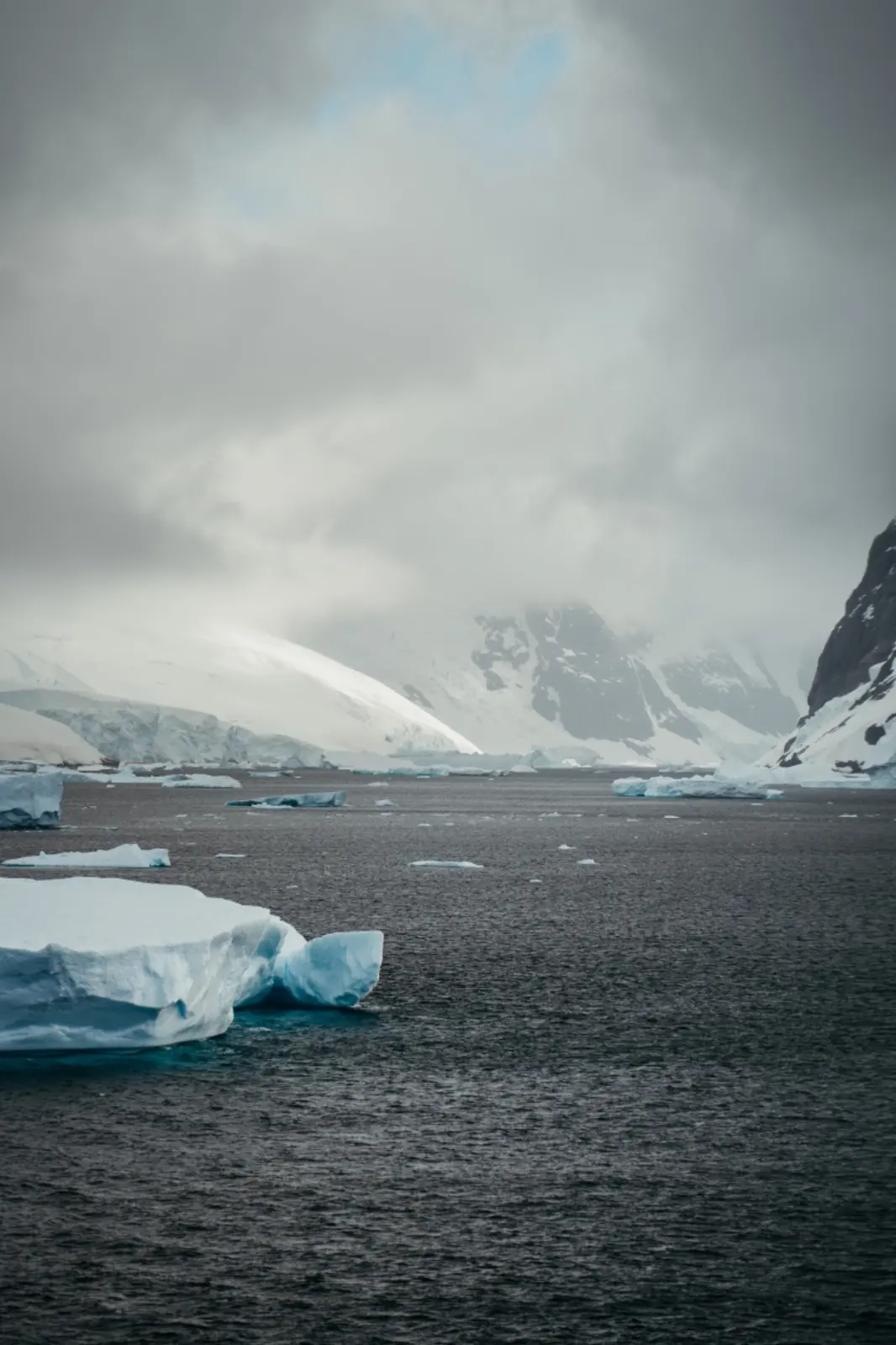 Misty polar channel dotted with floating ice.