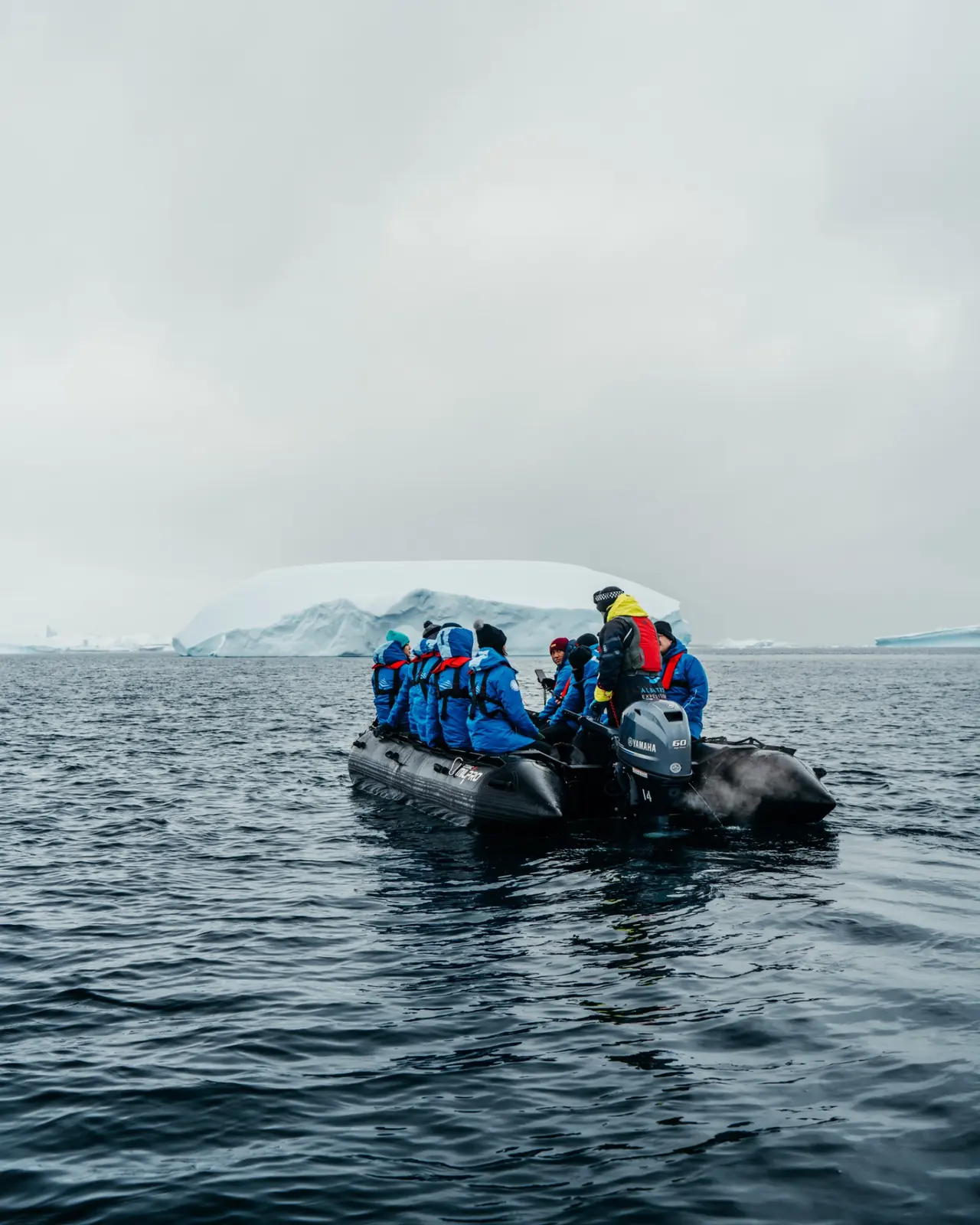 Expedition travellers gathered in a zodiac amid drifting ice.