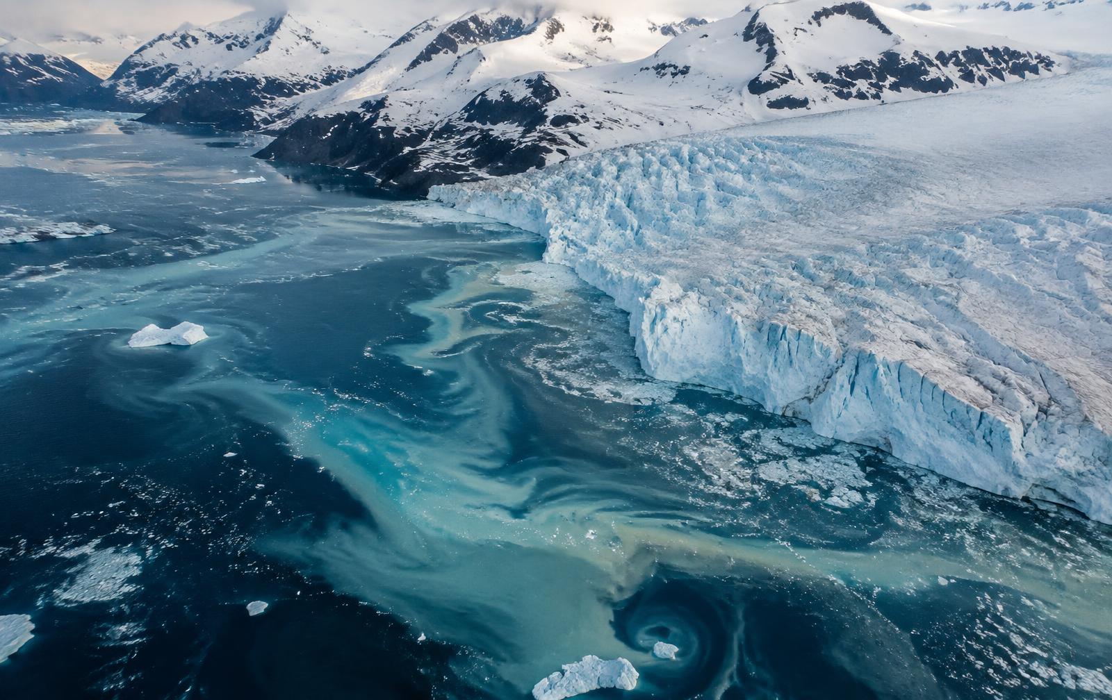 Aerial view of a glacier front meeting turquoise polar water