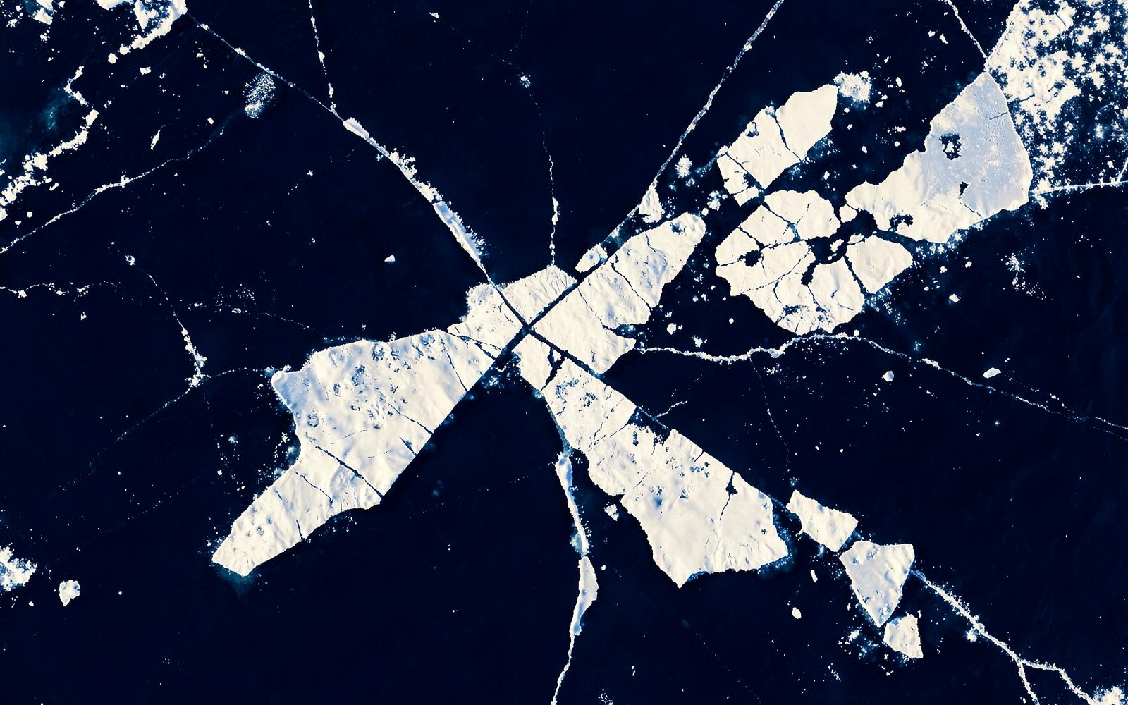 Aerial view of arctic sea ice breaking into pale floes
